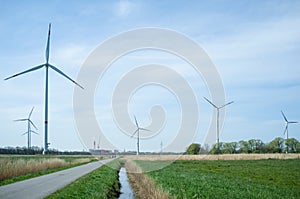 Wind turbines in the fields in the countryside, next to the road. Clean energy concept.