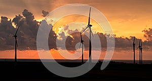 Wind turbines in front of the sea at sunrise