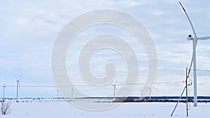 Wind turbines on a frosty winter day in a snowy field