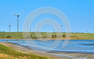 Wind turbines generating electricity on blue sky background - th