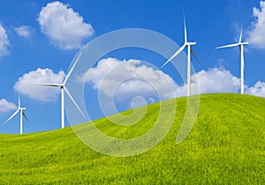 Wind turbines generating electricity on grass hill meadow and blue sky