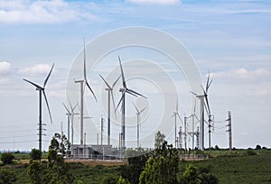 Wind turbines generating electricity with high voltage electrical power pylon substation