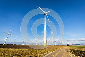 wind turbines generating power on the side of a rural road