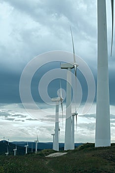Wind turbines. Wind generators. Wind turbine generators. Alternative energy. Windmills over dramatic cloudy sky. Industrial