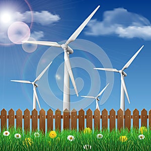 Wind turbines on a grass field behind a wooden fence