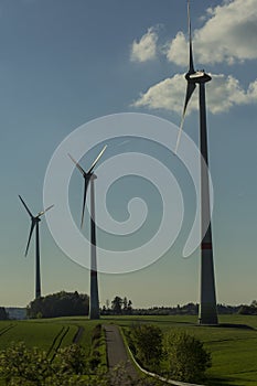 Wind turbines on green field with path. Green â€“ ecological, renewable and sustainable alternative to traditional sources of