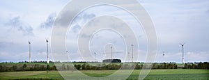 Wind turbines and green fields under blue cloudy sky in german eifel