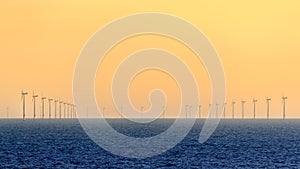 Wind turbines of the Hornsea Offshore Wind Farm, offshore windfarm off the UK coast in the North Sea at sunset