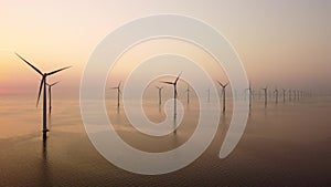 Wind turbines offshore producing electricty during sunset