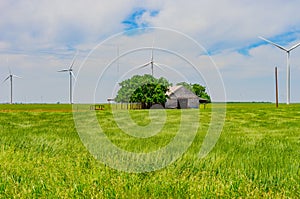 Wind turbines and an old barn in the plains of Texas