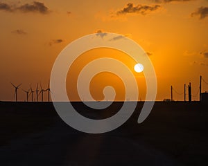 Wind turbines at orange sunset in the rural of Corpus Christi, Texas, USA