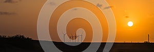 Wind turbines at orange sunset in the rural of Corpus Christi, Texas, USA