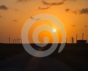 Wind turbines at orange sunset in the rural of Corpus Christi, Texas, USA