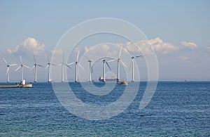 Wind turbines park and cargo ship passes in international water