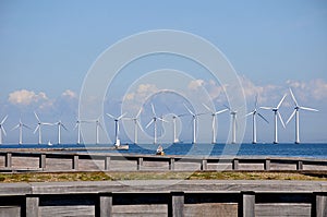 Wind turbines park and cargo ship passes in international water