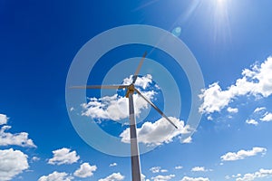 Wind turbines for power generation on hill against blue sky