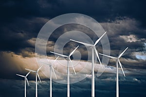 Wind turbines power generators on a stormy dramatic sky Renewable and sustainable energy concept photo