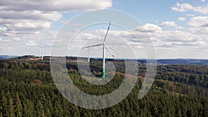 Wind turbines rotating on some forest hills filmed with forward movement  in 4k