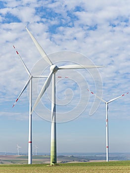 Wind turbines in a rural landscape with blue sky und white clouds