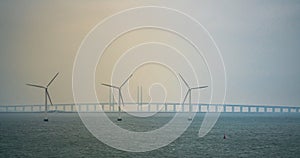 Wind turbines at sea with the Oresund bridge in the background
