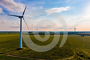 Wind turbines set up in green field, summer landscape. Energy concept