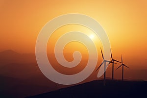 Wind turbines silhouette on mountain at sunset
