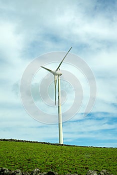 Wind turbines stand tall against a cloudy sky on Terceira Island, Azores.