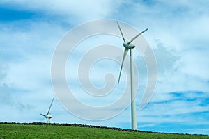 Wind turbines stand tall against a cloudy sky on Terceira Island, Azores.