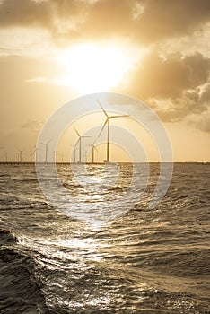 Wind turbines at sunset. Ecology wind against cloudy sky background with copy space