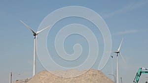 Wind turbines turning along a soil hill