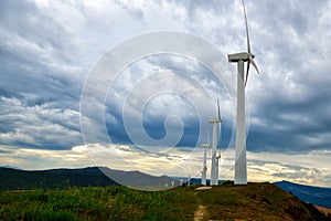 Wind turbines. Wind generators. Wind turbine generators. Alternative energy. Windmills over dramatic cloudy sky. Industrial