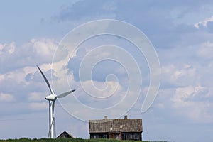 Wind turbines and a wooden house against a blue sky