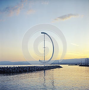 The wind vane on the pier of the Lausanne marina in Switzerland at sunset