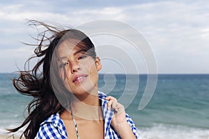 Wind: woman with tousled hair at the sea