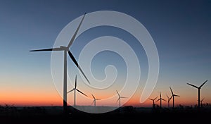 Windfarm at dawn in front of a colorful sky