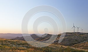 Windfarm on moutainscape by sunset photo