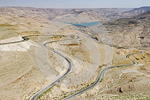 Winding asphalt road through desert and valley