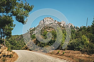 winding Asphalt road with a view of a lonely mountain with a rock in the countryside area in Turkey