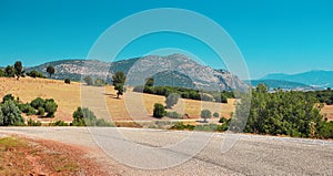 Winding Asphalt road with a view of a lonely rocky mountain in the countryside area in Turkey