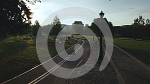 A winding bike path in the park. It winds through the trees and bushes. Filmed at dawn, at sunrise. Aerial photography