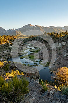 Winding bubbling river at Hot Creek Geological Site in Mammoth Lakes California, with the Eastern Sierra Nevada mountains in