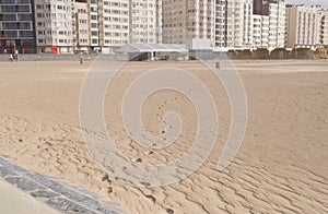 winding chain of human footprints in the sand to the trash in the ostend