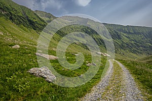 Winding country road in a mountain valley. The Fagaras Mountains, Carpathians, Romania