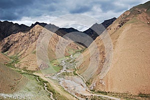 Winding dirt road snaking through a picturesque mountainous landscape, creating a scene of solitude