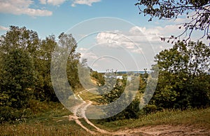 The winding dirt road between the trees. Autumn landscape with t