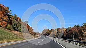 Winding highway with colorful foliage in the fall, Upstate NY, USA