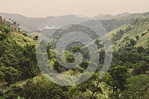 Winding mouintain road, mountains and lush green tropical vegetation on overcast day at Ring Road, Cameroon, Africa