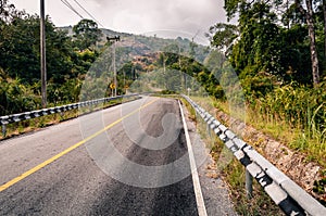 Winding mountain asphalt road through the autumn forest.