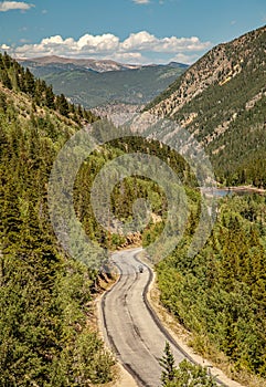 Winding Mountain Road with Motorcyclist in Distance