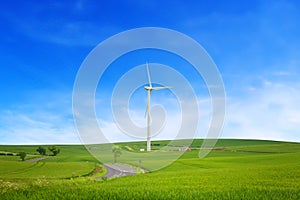 A winding road in a field with a windmill producing electricity